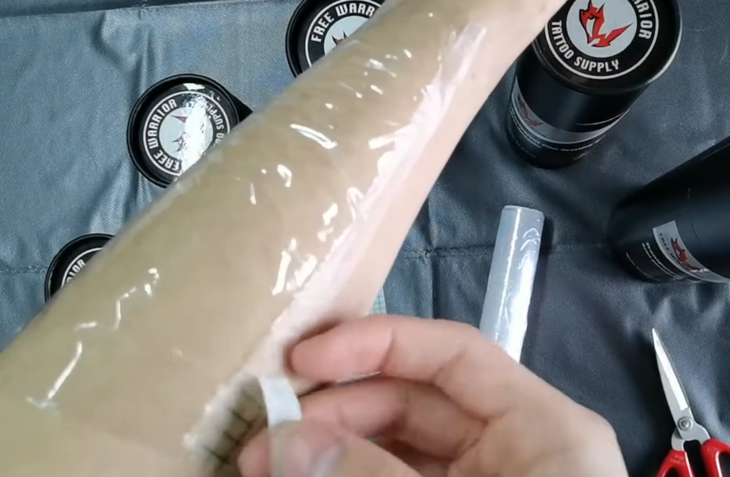 How long should a tattoo be covered with plastic wrap?